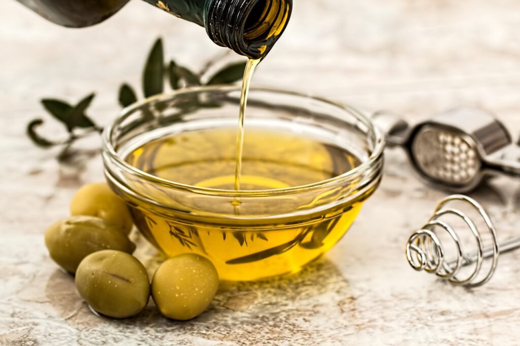 olive oil pouring into a glass bowl